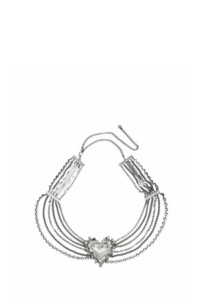 Collar de plata con múltiples cadenas y un gran colgante decorativo en forma de corazón en el centro.
