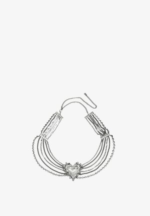 Collar de plata con múltiples cadenas y un gran colgante decorativo en forma de corazón en el centro.