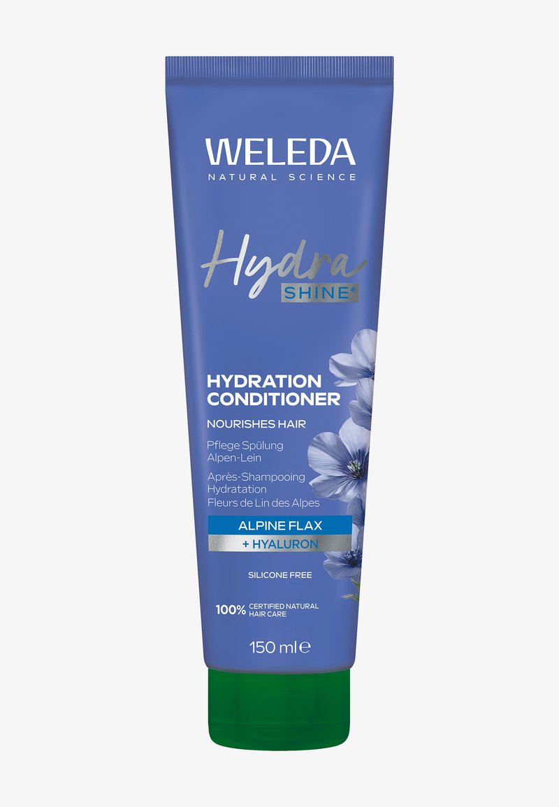 Blauwe tube van Weleda Hydration Conditioner, met bloemmotief, groene dop en zilveren accenten. De tekst bevat "Hydra SHINE" en "Alpenvlas."