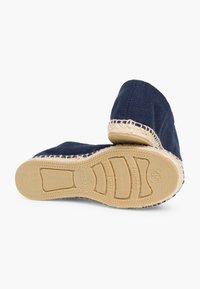 Marineblå kanvas espadrilles med jutekant og gummisål, der har en tekstureret overdel og fleksibel design, ideel til afslappet brug.