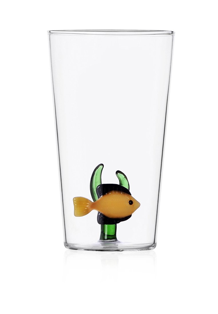 Przezroczysta szklanka z żółtą rybą i zieloną rośliną wodną wewnątrz, o gładkiej powierzchni i cylindrycznym kształcie.