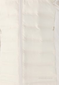 Lätt, krämfärgad puffjacka med horisontella quiltade sektioner, dragkedja fram och "ENDURANCE"-logotyp på den nedre högra sidan.