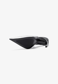 Hopeapintainen kärjellinen stiletto-korkokenkä, kuvattu pohjasta valkoista taustaa vasten.