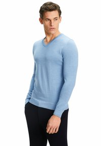 Helles blauer V-Ausschnitt-Pullover aus glattem Material; taillierte Passform mit langen Ärmeln und gerippten Saumdetails, kombiniert mit dunklen Hosen.
