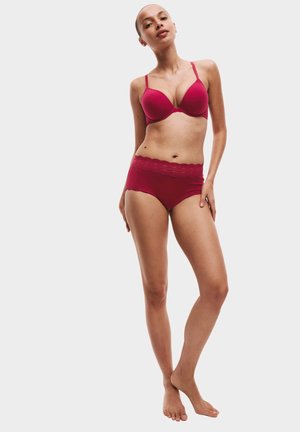 Fuchsia bh met gladde cups en verstelbare bandjes, gecombineerd met bijpassende high-waisted panties met golvende randjes.