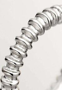 Pulsera de plata con una serie de eslabones redondeados y texturizados con un acabado pulido, que crea una apariencia brillante y reflectante.