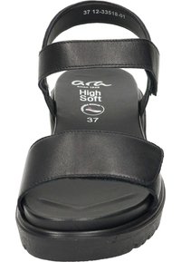 Sandal nera con doppi cinturini regolabili, suola piatta e soletta imbottita. Realizzata in pelle liscia, presenta un design minimalista e un branding sottile.