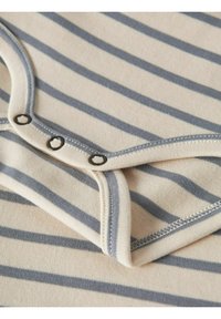 Bodysuit en coton rayé crème et marine, avec une fermeture à pression et un bord contrastant bleu clair autour du cou et des jambes.