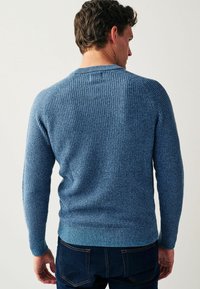 Blauwe gebreide trui met een getextureerde stof, geribde manchetten en zoom, en een ronde halslijn, gezien vanuit de achterkant. Geschikt voor casual gebruik.