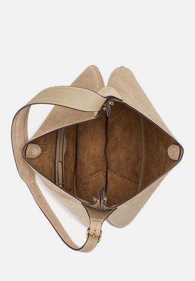 Smėlio spalvos zomšinė rankinė su plačia anga, vidine kišene užtrauktuku ir subtiliomis siūlėmis palei kraštus ir dirželį.