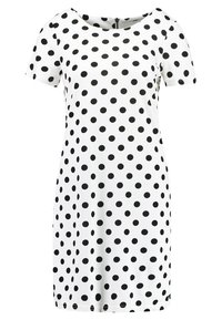 Krátké šaty z bílé látky s kulatým výstřihem, které mají černý puntíkovaný vzor a skrytý zip na zadní straně.