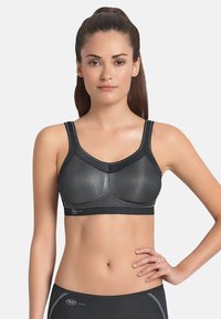 Sostenedor deportivo negro con paneles de malla, forma estructurada y banda elástica inferior. Cuenta con tirantes ajustables y costuras planas para mayor comodidad.