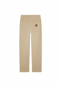 Pantalons de survêtement beiges avec une taille élastique confortable, deux poches arrière et un patch logo circulaire sur la poche droite. Texture lisse.