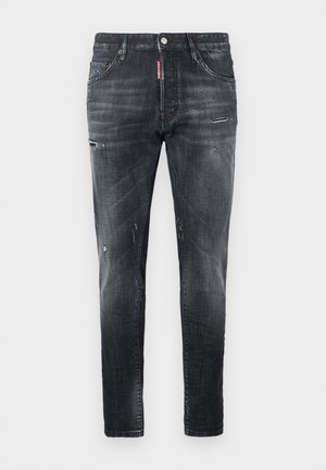 Svarta jeans i denim med smal passform, slitna detaljer, fem fickor och knappstängning med en märkt etikett på midjebandet.