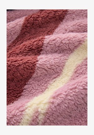 Fleece sega ar teksturētu virsmu, kurai ir krāsu gradients ar dziļu burbona sarkano, maigu rozā un krēma svītrām. Daudzkrāsaina un mīksta.