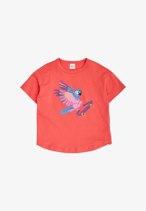 Korallinen lyhythihainen t-paita, jossa värikäs papukaijagrafiikka pitelemässä violettia skeittilautaa keskipisteessä lennossa.