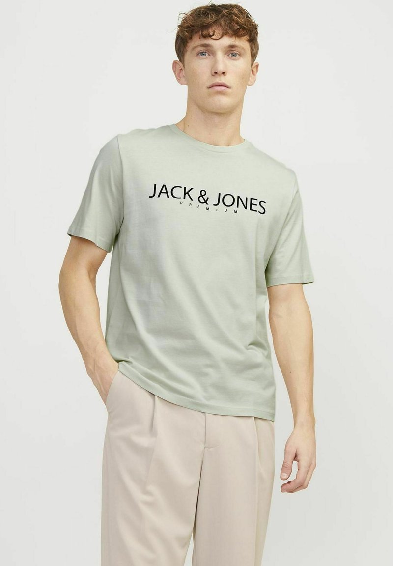T-shirt en coton vert clair à manches courtes avec "JACK & JONES PREMIUM" imprimé en lettres noires en gras sur la poitrine.