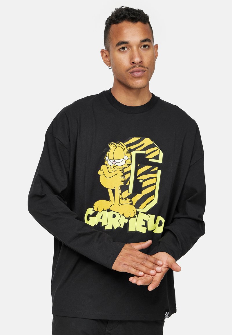 T-shirt noir à manches longues arborant un grand graphique de Garfield jaune et vert avec le texte "G" et "GARFIELD". Fait en tissu de coton doux.