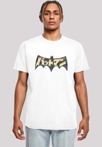 Hvit bomulls T-skjorte med en stor svart og gull flaggermus-logo med japansk tekst. Korte ermer og rund hals. Avslappet passform.