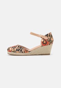 Sandalias de cuña con estampado floral, puntera cerrada, tacón de fibra natural y tira con hebilla. Los colores incluyen acentos en rosa, naranja y verde.