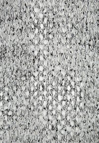 Tessuto metallico con intricati piccoli motivi a diamante in argento e nero. La texture è tessuta, creando una superficie riflettente con profondità.