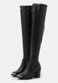 Stivali neri al ginocchio in materiale sintetico liscio, con un tacco spesso e una punta in tonalità argento. Design elegante e aderente con cuciture minime.