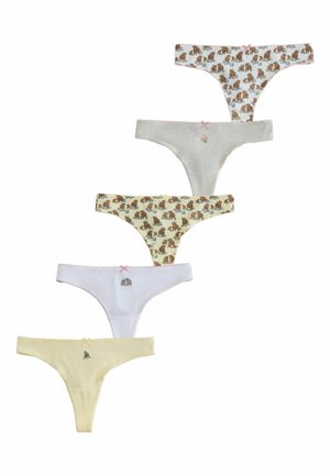 Žena nosi biele spodné prádlo s hnedým medveďom a kvetinovým vzorom, upravuje pás a sivý krátky top.