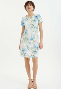 Kwiatowa sukienka krótko rękawowa z lekkiego materiału z niebieskimi i zielonymi wzorami kwiatowymi na białym tle; projekt do kolan z okrągłym dekoltem.