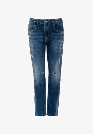 Kék farmernadrág, enyhén kifakult mosással és kopott szakadásos részletekkel az elülső combokon és térdeken, gombos és cipzáras zárral.