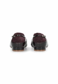 Due scarpe senza schienale con una parte superiore in suede bordeaux scuro e pelle verniciata nera lucida, con un piccolo tacco e dettagli in fibbia argentata.