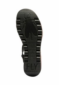 Černá gumová podrážka s texturovaným gripem, se značkou loga fly. Podrážka má rýhy a zaoblenou část na prstech, označenou "FLY LONDON."