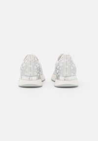 Ein Paar weiße Sneaker mit grauem DKNY-Logo-Muster, silbernen Fersenakzenten und markanten Zuglaschen, von hinten auf einem weißen Hintergrund betrachtet.