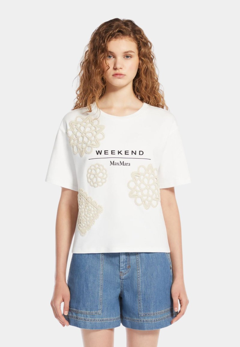 Tricou alb din bumbac cu modele decorative bej asemănătoare croșetei, branding "WEEKEND" și mâneci scurte. Asortat cu șorturi din denim.