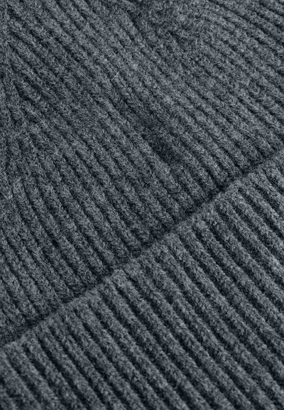 Primo piano di tessuto lavorato a maglia grigio scuro con texture a coste visibile e fibre morbide e lanuginose disposte in motivi diagonali e orizzontali.