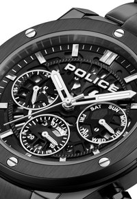 Čierne nerezové hodinky so skeletovým ciferníkom, tromi subciferníkmi pre dátum a deň, striebornými akcentami a výraznými číslicami.