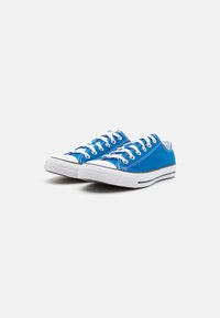 Sneaker in tela blu con lacci bianchi, suola in gomma e strisce nere. Punta arrotondata e motivo cucito sulla parte superiore. Design pulito.