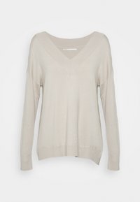 Pull beige clair à manches longues avec un col en V profond, coupe décontractée, détails côtelés au col et à l'ourlet, texture lisse et fentes latérales.