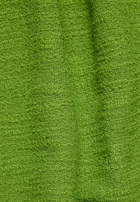 Strukturiertes grünes Stoffgewebe mit einem gewebten Muster, das eine weiche, geschlossene Oberfläche aufweist und verschiedene Grüntöne zeigt.