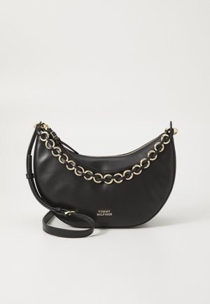 Sort læder håndtaske med en afrundet form, der har guld kæde detaljer og en lynlåslukning. Indeholder en aftagelig rem. Brandlogoet er synligt.