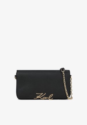 Must musta kott, millel on kuldne ahel ja kuldne "Karl" signatuurlogo esiküljel.