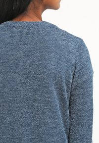 Maglione azzurro lavorato a maglia con una finitura testurizzata, scollatura rotonda e maniche lunghe. Apparente morbido e casual, con una vestibilità leggermente rilassata.
