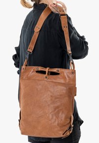 Borsa a spalla in pelle marrone con finitura testurizzata, tracolla regolabile, apertura superiore e dettagli in metallo.