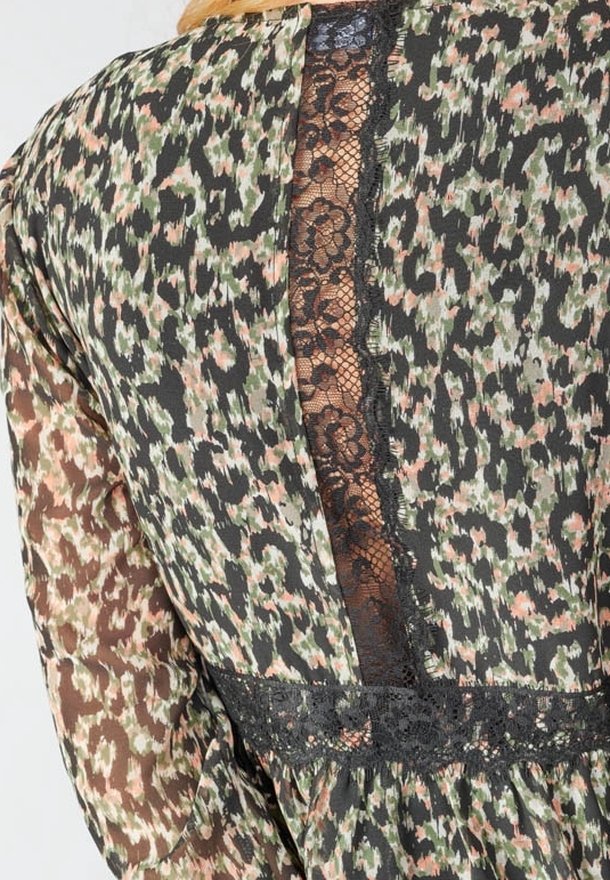 Dos d’une robe à manches longues avec imprimé léopard vert, marron et noir et un panneau vertical en dentelle noire au centre.