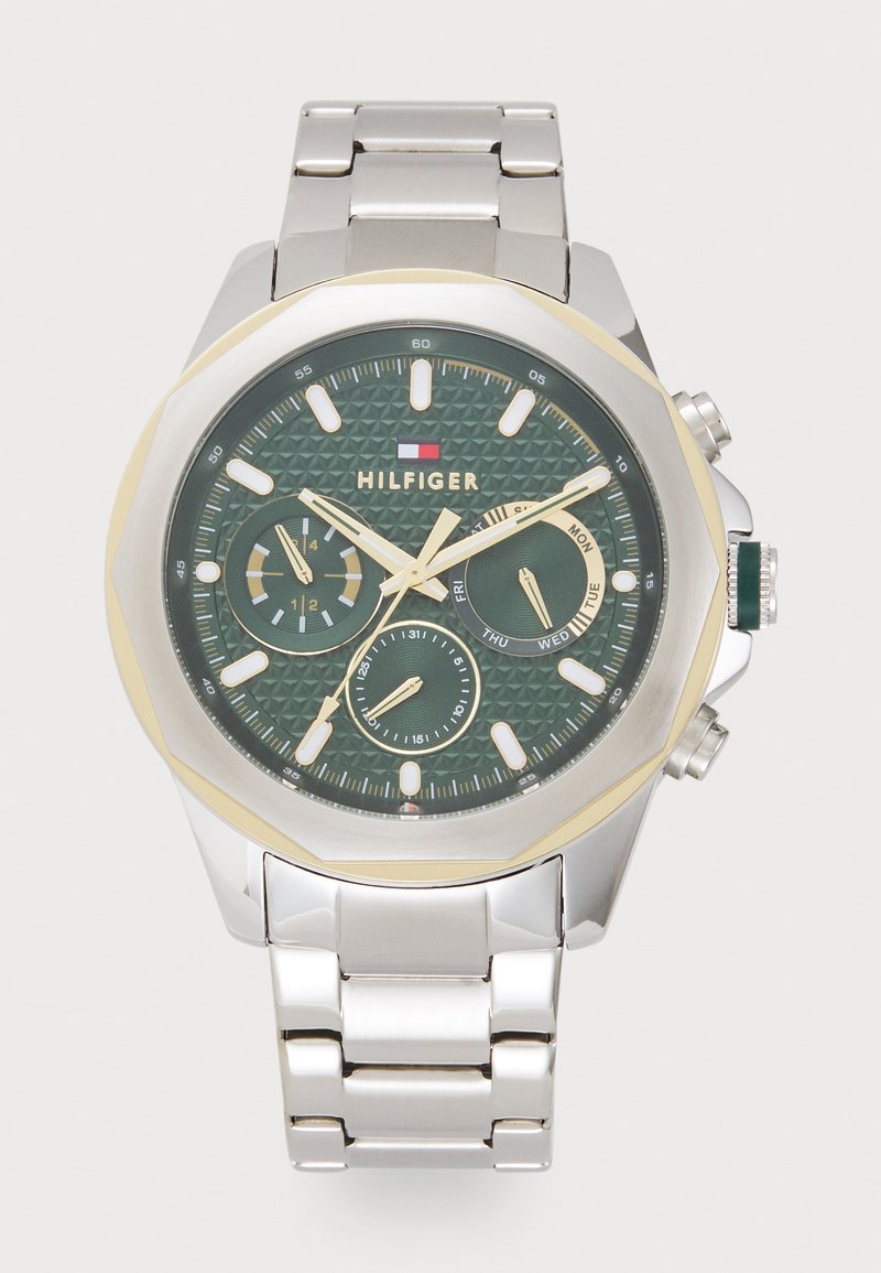 Groene wijzerplaat horloge met een gestructureerd oppervlak, gouden accenten, een zilveren roestvrijstalen band en sub-dials voor dag- en datumnotaties.