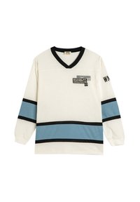 Langärmliges Shirt in Creme mit horizontalen Streifen in Schwarz und Hellblau. Der V-Ausschnitt hat ein abstraktes Grafikdesign auf der linken Brust.