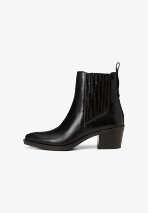 Bottine en cuir noir avec un bout pointu, des panneaux latéraux en élastique texturé et un petit talon carré pour plus de stabilité.