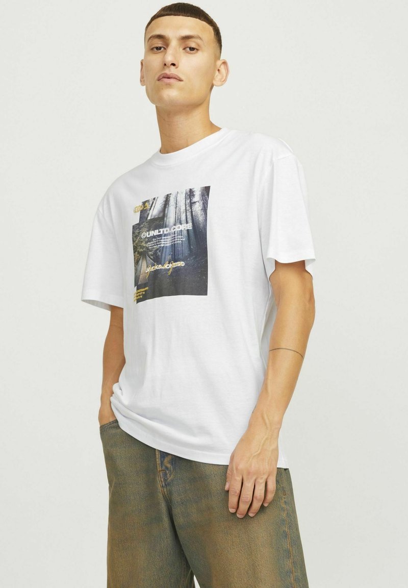Hvid bomulds T-shirt med et frontprint med skovmotiver og tekst. Løs pasform, korte ærmer og rund halsudskæring.