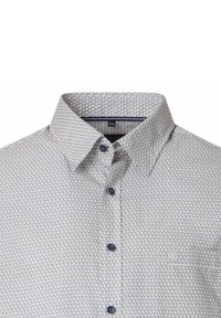 Kraag en bovenkant van een lichtgepatineerde button-up shirt met blauwe knopen, met zichtbaar maatlabel 41/42 aan de binnenkant van de kraag.