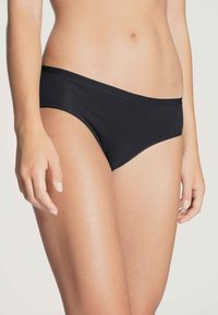 Black cotton panties with a smooth texture, low-rise design, and elastic waistband. Features stitching along the edges.