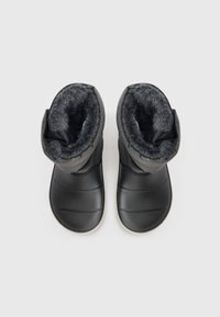Bottes d'hiver noires avec un haut en tissu texturé, doublure grise douce et semelle lisse et arrondie avec des rainures horizontales.